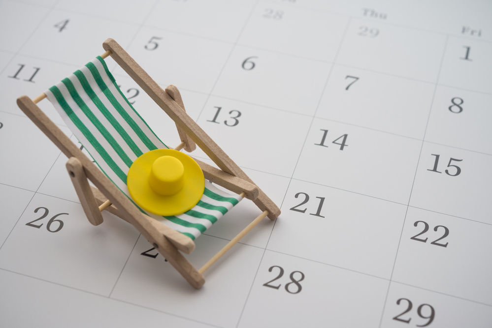 Green beach chair and hat on white blank calendar background copy space. Annual leave travel period for relaxation concept. Period of paid time off (PTO) granted to employees by their employer