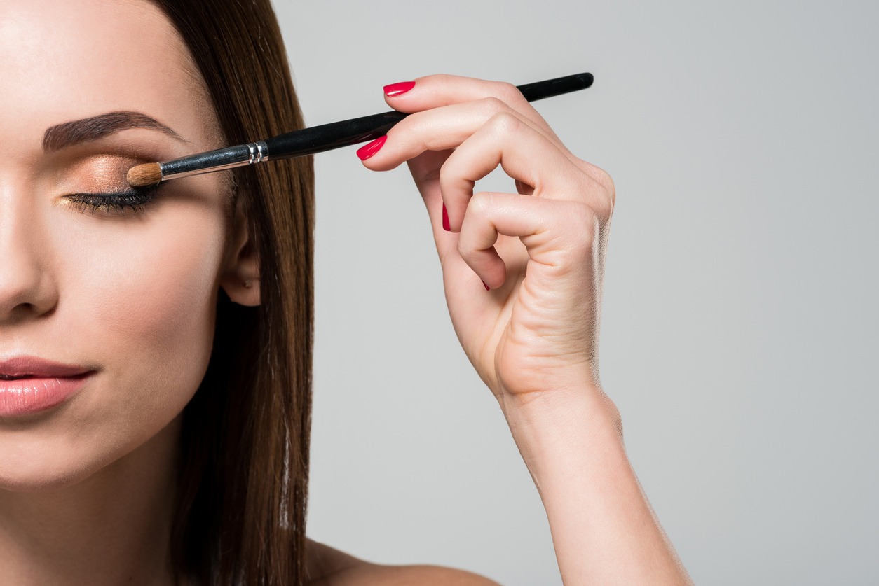 A woman applying eyeshadow using the eyeshadow brush
