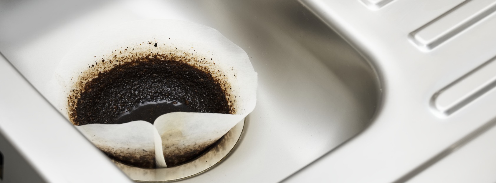 Coffee filter paper draining in kitchen sink